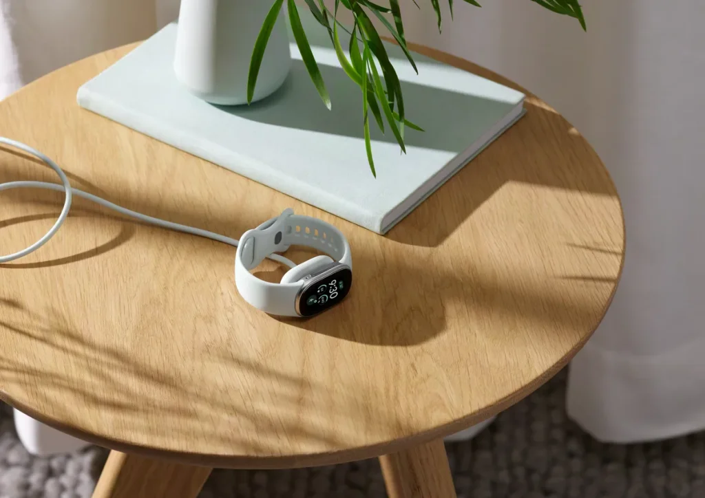 カフェのテーブルに置かれたGoogle Fitbit Edge。日常のファッションにも馴染むスタイリッシュなデザイン。